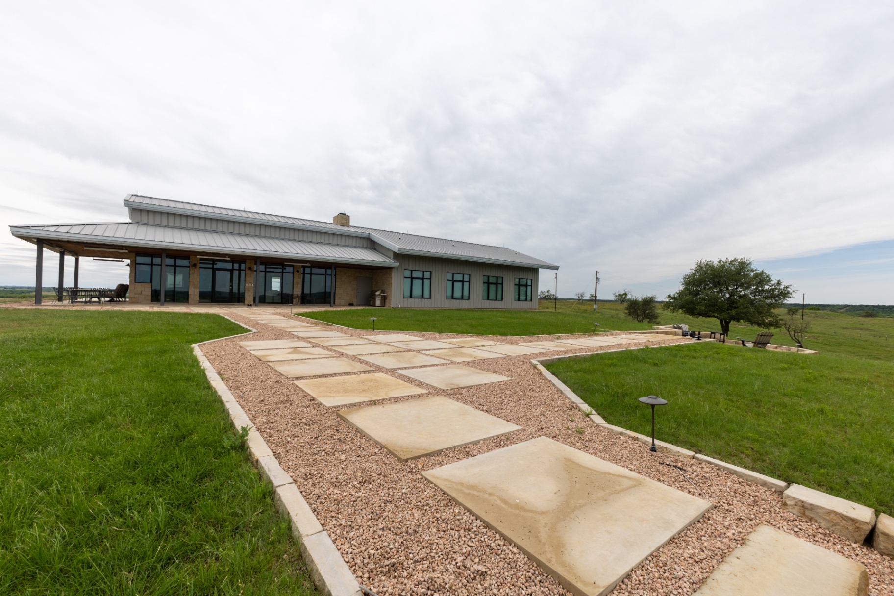 Guest House exterior with covered porch and metal roof — Trinity Valley Ranch Deer, Coleman Texas