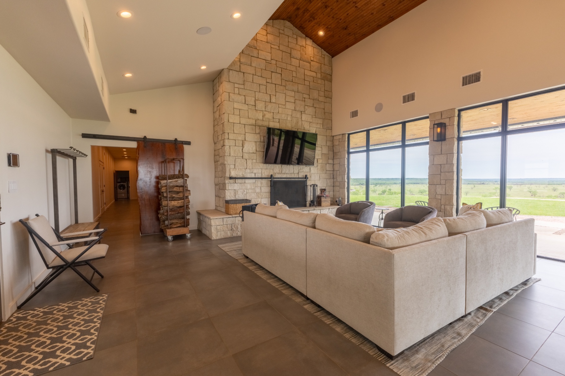 Guest House living room with stone fireplace and ranch views — Trinity Valley Ranch Deer, Coleman Texas