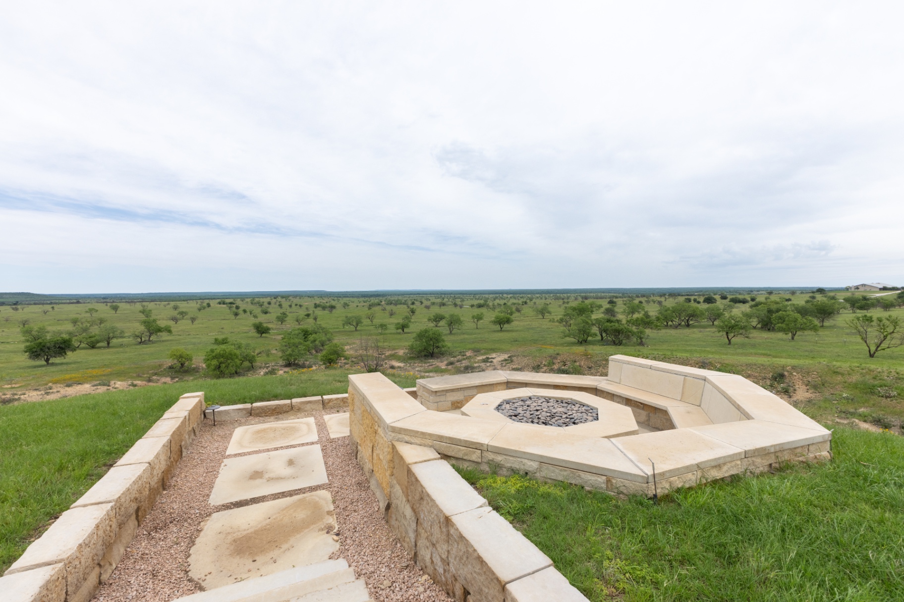 Stone fire pit with sweeping Texas hill country views — Trinity Valley Ranch Deer, Coleman Texas