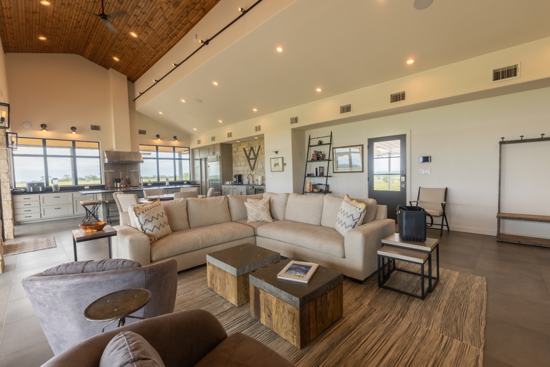 Guest House great room with vaulted ceilings, stone fireplace, and panoramic windows — Trinity Valley Ranch Deer, Coleman Texas