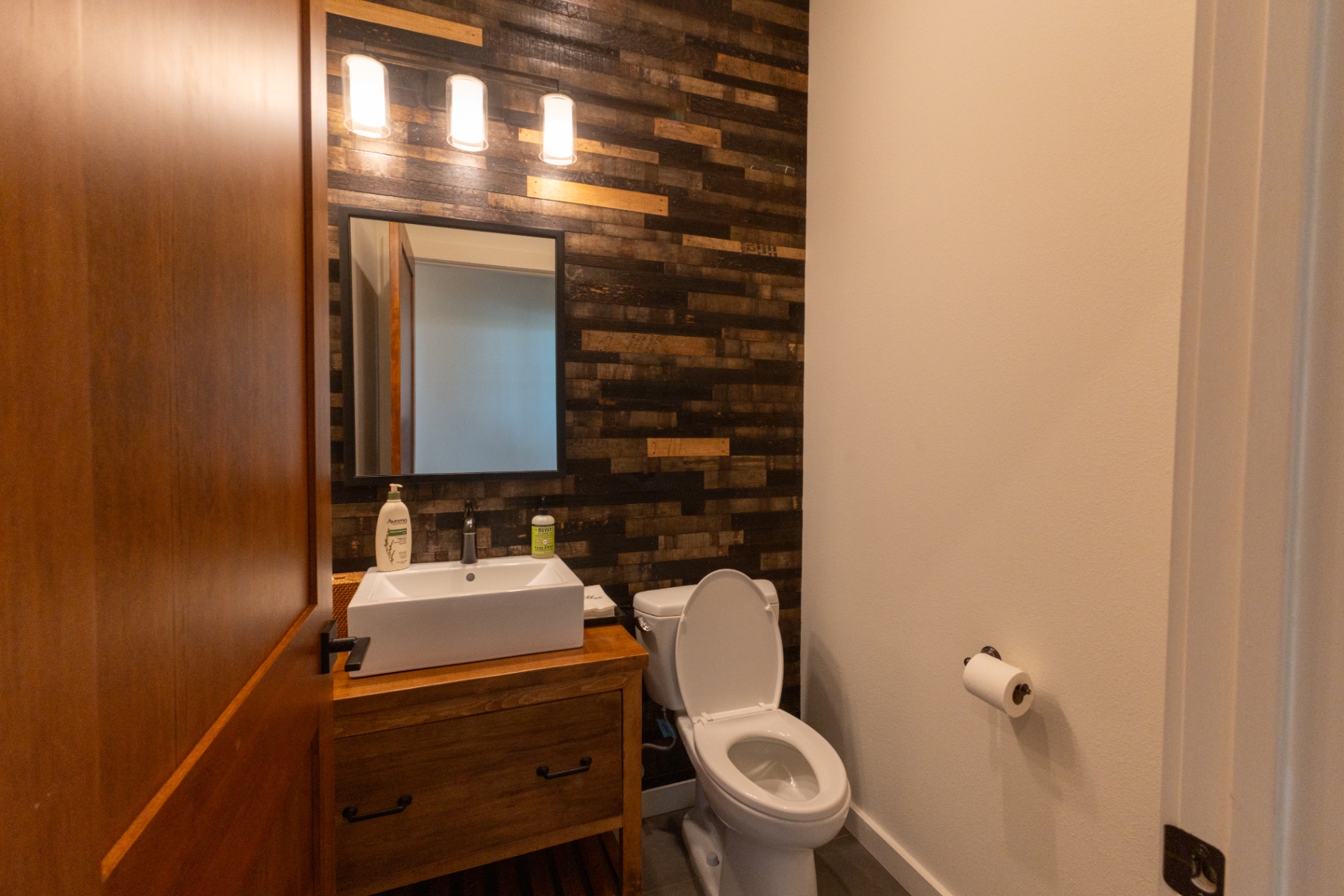 Guest House powder bath with reclaimed wood accent wall — Trinity Valley Ranch Deer, Coleman Texas