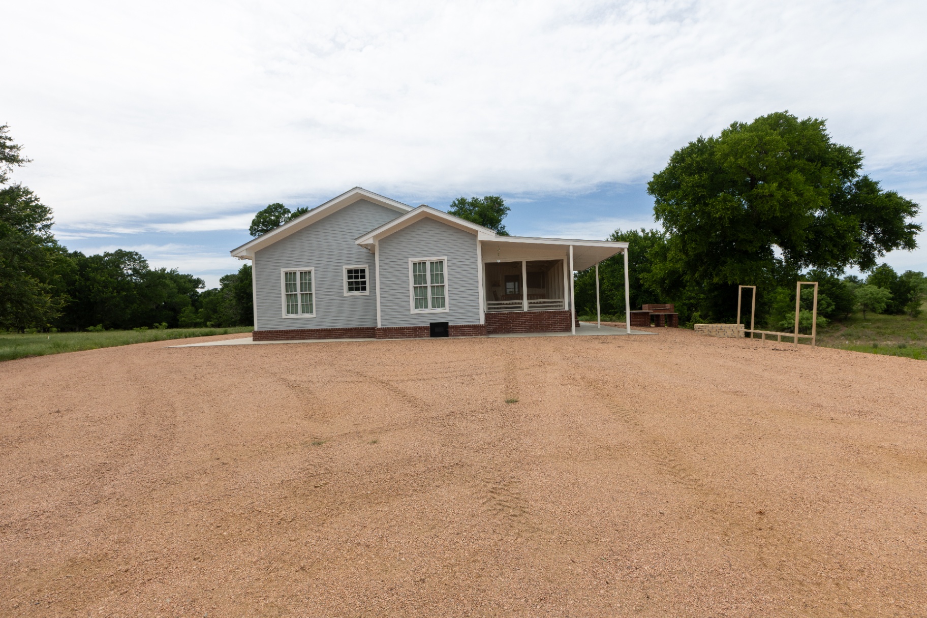 Farm House exterior with wraparound porch and gravel drive — Trinity Valley Ranch Deer, Coleman Texas