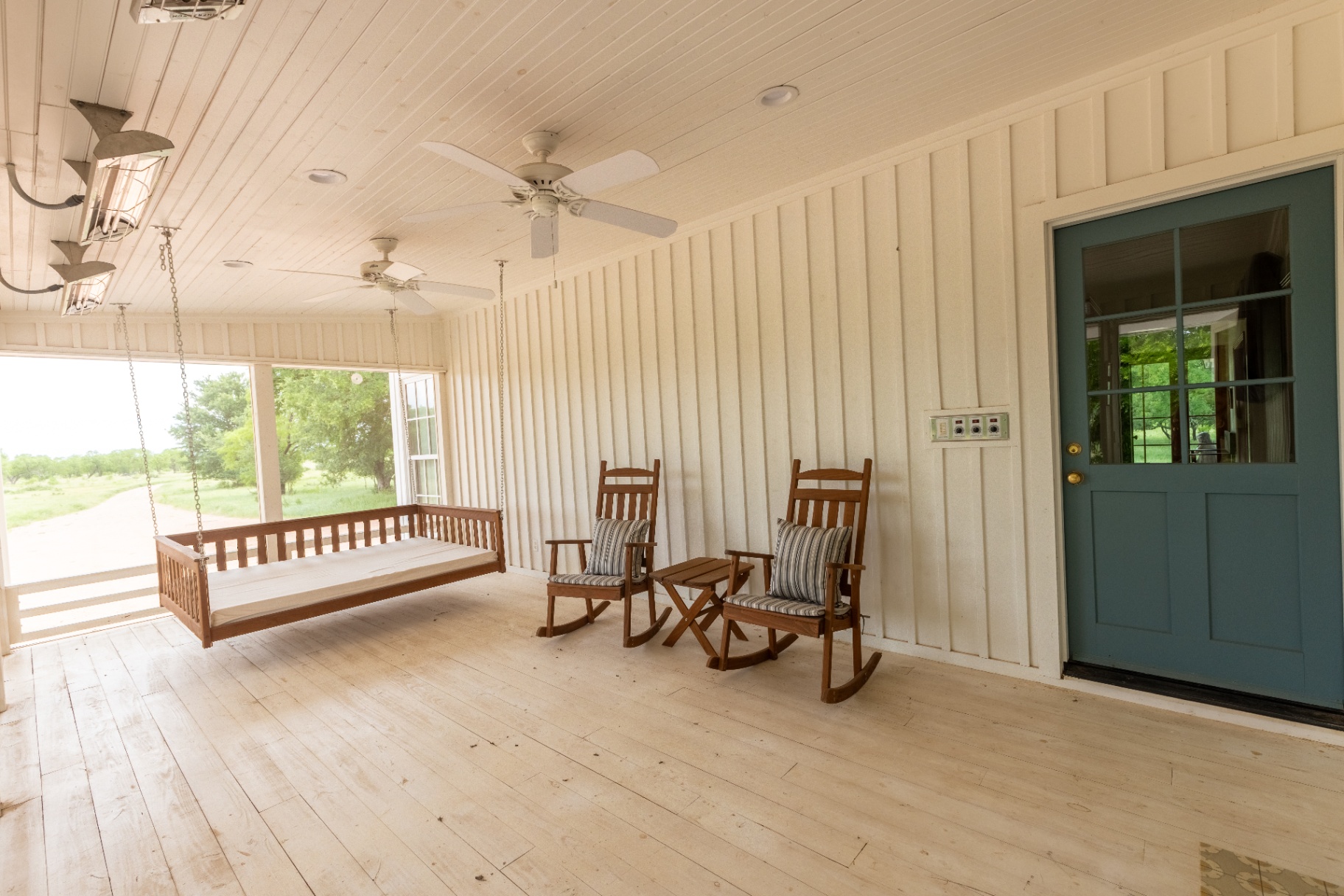 Farm House wraparound porch with hanging swing bed and rocking chairs — Trinity Valley Ranch Deer, Coleman Texas