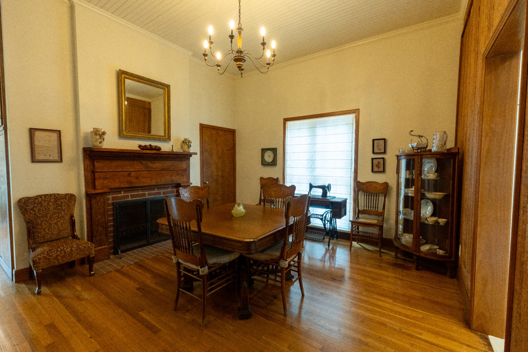Farm House formal dining room with antique table, fireplace, and china cabinet — Trinity Valley Ranch Deer, Coleman Texas