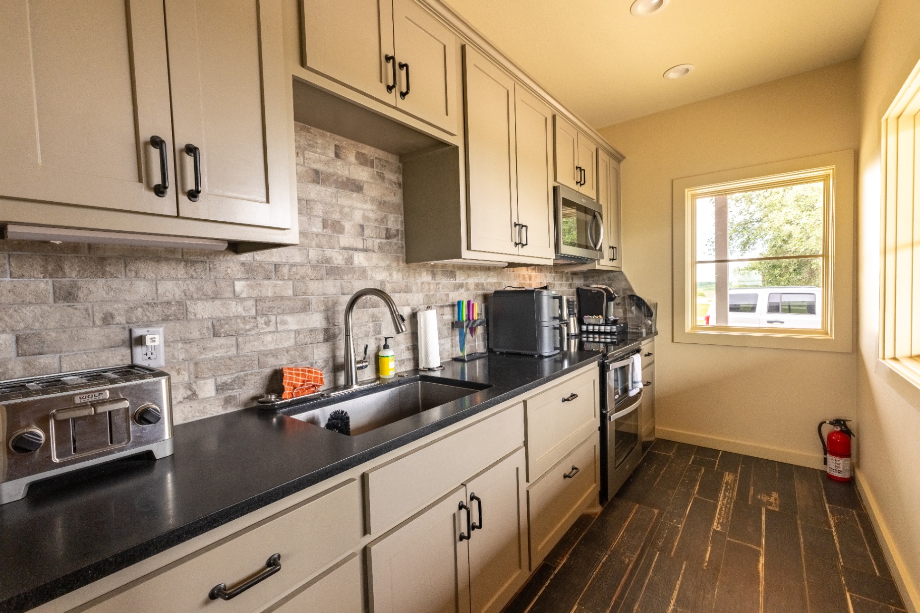 Saloon kitchenette with stone backsplash and coffee station — Trinity Valley Ranch Deer, Coleman Texas